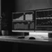 Automated trading software charts displayed on dual monitors and a tablet.
