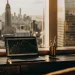 Wealth-building strategies for investors shown on a laptop with globe and city view.