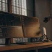 Automated trading charts displayed on monitors with a robotic arm.