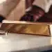 Investing in gold: Gold bar and magnifying glass.